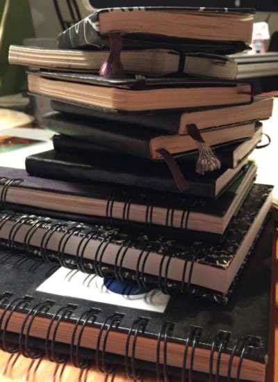 A pile of sketchbooks