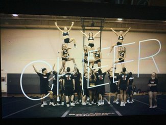 Title screen for the show Cheer showing the team intertwined with the show name while on the mat